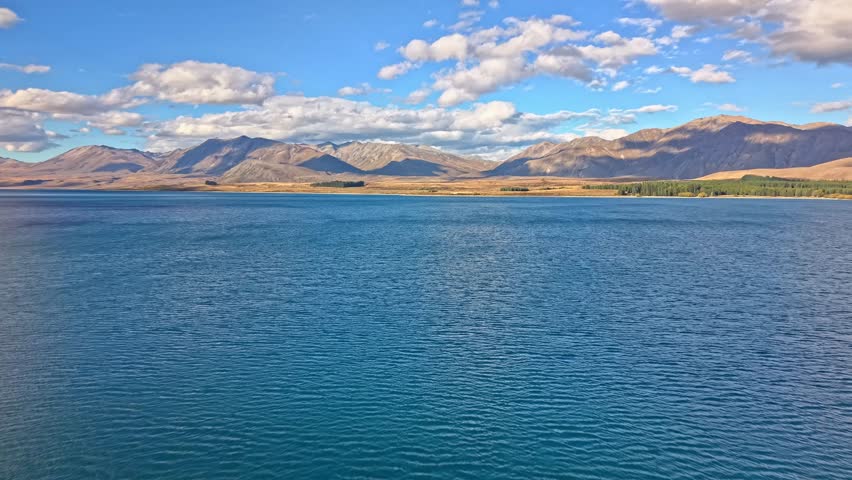 Blue lake with mountains and sky in Tekapo, New Zealand at daylight
