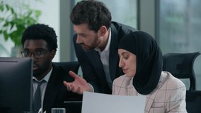 Diverse business group discuss project in office African American Caucasian businessmen businesswoman in hijab computer documents teamwork corporate studying company training three multiethnic workers - Powered by Shutterstock - Get 15% off with code: PIKWIZARD15