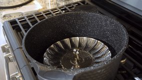 In a modern white kitchen, large organic asparagus is being steamed in a sizable cooking pot. - Powered by Shutterstock - Get 15% off with code: PIKWIZARD15