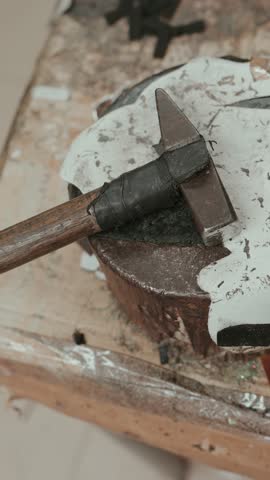 Vertical detailed view of shoemaker hammer resting on rustic work table