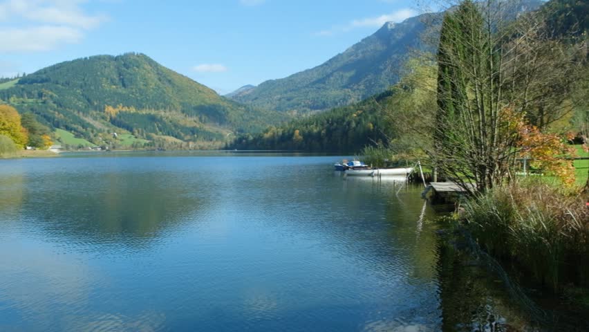 Autumn mountain landscape, mountains near lake, reflections in the water.