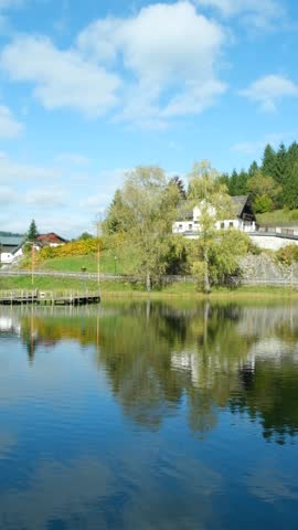 Autumn mountain landscape, mountains near lake, reflections in the water.