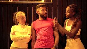 Diverse group of three athletic friends resting and having a friendly conversation together after a training session at the gym. Warm lighting and a relaxed atmosphere create a positive social scene - Powered by Shutterstock - Get 15% off with code: PIKWIZARD15