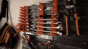 Female mechanic choosing wrench from garage wall organizer - Powered by Shutterstock - Get 15% off with code: PIKWIZARD15