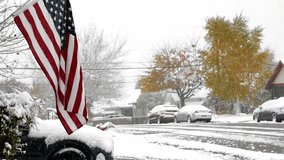 US flag gently sways in the light breeze from a winter storm which has blanketed the streets of a residential neighborhood in snow. - Powered by Shutterstock - Get 15% off with code: PIKWIZARD15