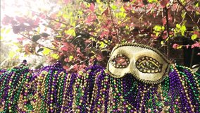 Slow-motion pan with light flare of an iron fence covered in colorful carnival beads and topped with a Mardi Gras mask outdoors. Perfect for celebration, festival, and vibrant cultural visuals. - Powered by Shutterstock - Get 15% off with code: PIKWIZARD15