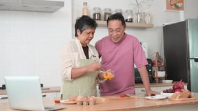 Happy Asian senior couple cooking together in kitchen, Making eggs for breakfast - Powered by Shutterstock - Get 15% off with code: PIKWIZARD15