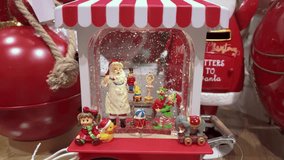 Festive Christmas shop display with Santa figurines, snow, and toy train diorama scene - Powered by Shutterstock - Get 15% off with code: PIKWIZARD15