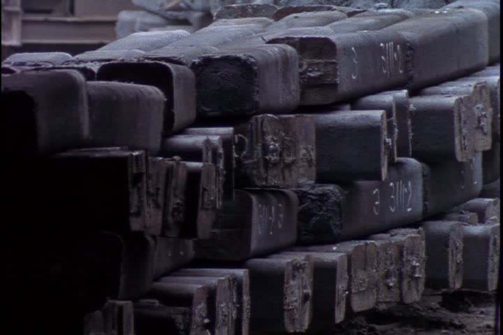 Steel works in Verkh-Isetsky, Russia. MS huge stacks of cold ingots moving past camera on flat bed railroad car.
