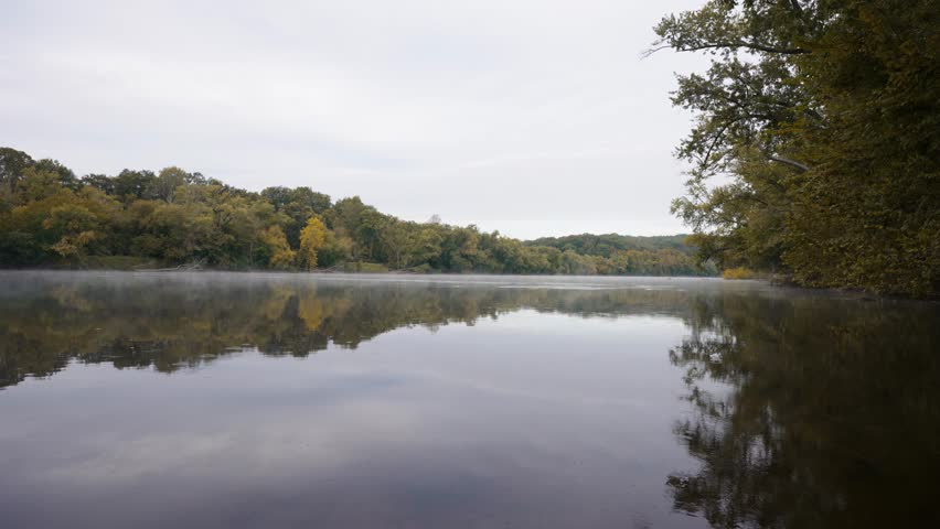 Morning mist drifting over the Upper James River at James River State Park, with early autumn colors reflected in the still water.