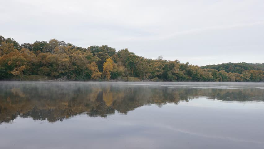 Morning mist drifting over the Upper James River at James River State Park, with early autumn colors reflected in the still water.