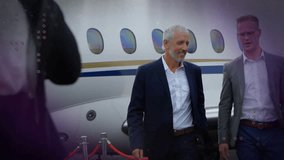 Mature man jr man stepping past red rope by jet gesturing as overlays highlighting business arrival. Aircraft, vip, executives, tarmac, photographer, silhouette, overcast - Powered by Shutterstock - Get 15% off with code: PIKWIZARD15