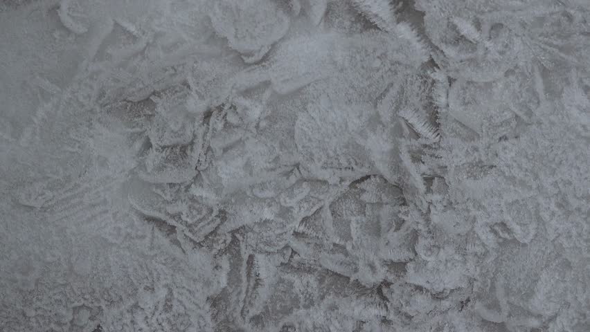 A Close-up of Frozen Frost Patterns on a Ice Surface With Intricate Crystals and Cold Winter Textures.
