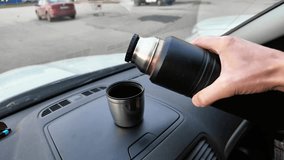 pouring coffee into cup on dashboard during roadside stop, close-up of hand holding black thermos, steam rising over stainless cup, urban parking background with distant cars, relaxed morning commute - Powered by Shutterstock - Get 15% off with code: PIKWIZARD15