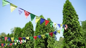Summer Celebration Decor: Rows of Multicolored Pennant Banners Swaying Gently in the Breeze Above Lush Green Trees, Symbolizing Celebration, Festivals, and Outdoor Events - Powered by Shutterstock - Get 15% off with code: PIKWIZARD15