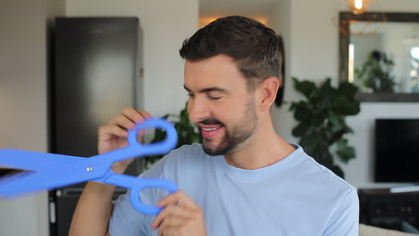 Man holding a pair of gigantic blue scissors 