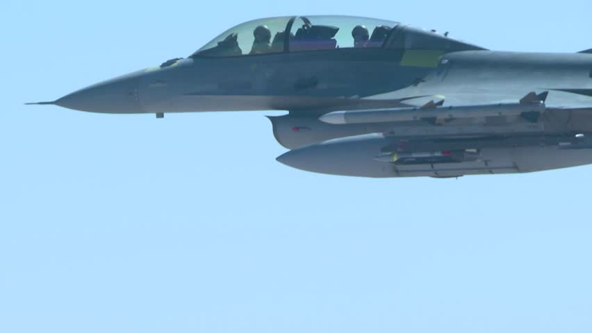 A US Air Force F-16 flew above the clouds, hovering with half of the aircraft visible. Air Force.