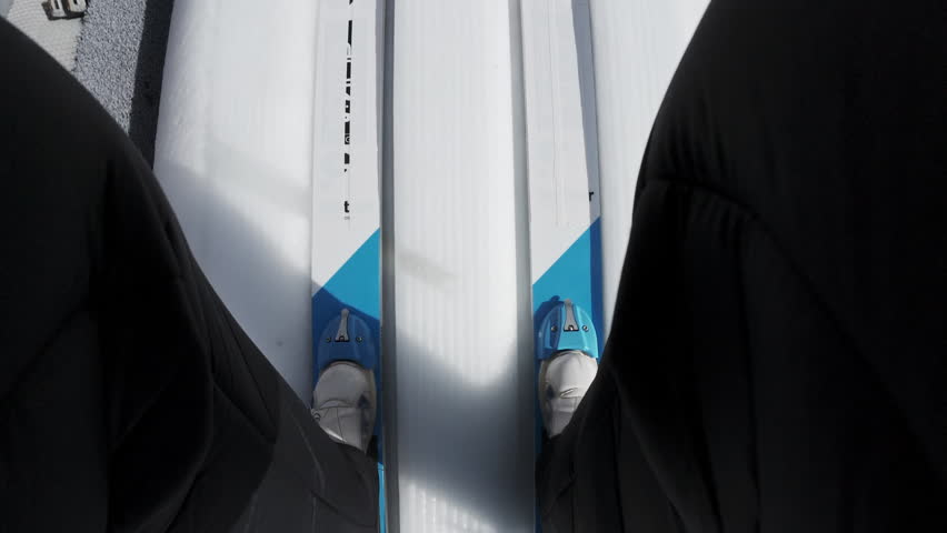Ski jumper on the skis sliding down a jumping ramp, achieving an explosive jump, flying and landing gently and safely on snow, point of view shot.