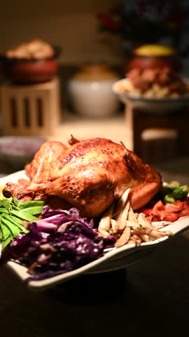 Close-up video shot of roasted turkey served with root vegetables, Brussels sprouts, mashed potatoes, green beans, carrots, fresh salad, stuffing, gravy and cranberry sauce for a festive Christmas