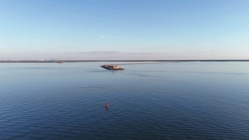 An expansive aerial shot of a Merrimac Memorial Bridge Tunnel crossing tranquil blue water, with a distant Newport News Harbor, open sky, conveying travel, infrastructure, and modern coastal scenery.