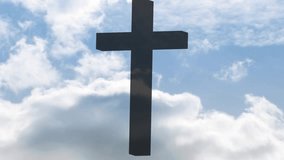 Cumulus banks drifting and sunlit edges passing behind dark cross silhouette, revealing blue sky. Crucifix, clouds, highcontrast, minimal, dramatic, halo, daytime - Powered by Shutterstock - Get 15% off with code: PIKWIZARD15