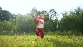 Young boy in field with football. Child is playing football on field. Young woman is playing with a superhero in nature and is carefree and playful. A young boy in a meadow playing with a lifestyle. - Powered by Shutterstock - Get 15% off with code: PIKWIZARD15