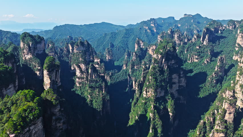 Aerial shot of majestic sandstone pillars and peaks with green forest in Zhangjiajie National Forest Park, Hunan Province, China.
