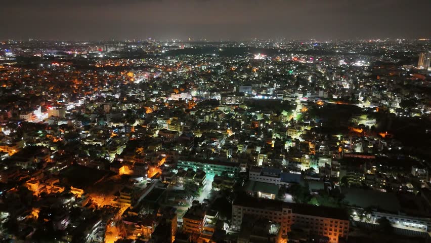 4K Aerial Night View of Bustling Metropolitan City – Urban Lights, Busy Roads, High-Rise Buildings, Nightlife Atmosphere, and Vibrant Tier-1 Suburban Development