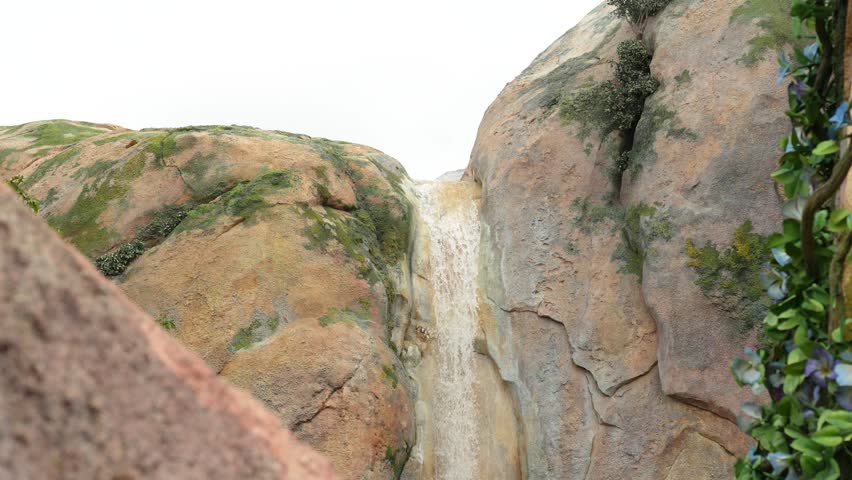Water falling down from the mountain rock cliff or waterfall. Environment natural footage.