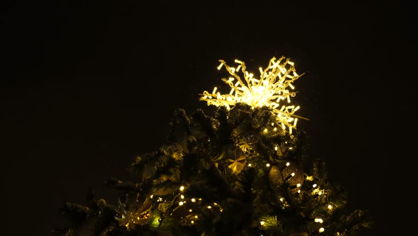 Christmas tree lights. Brilliant sparkling lights against the black sky. Outdoor New Year decorations. The concept of the holiday, the Advent of Christmas and New Year. Sparkling background of balls