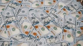 Close up shot of a hand placing metal police handcuffs onto a large pile of scattered one hundred dollar US bills, a theme for bribery, white collar crime, financial fraud and punishment. - Powered by Shutterstock - Get 15% off with code: PIKWIZARD15