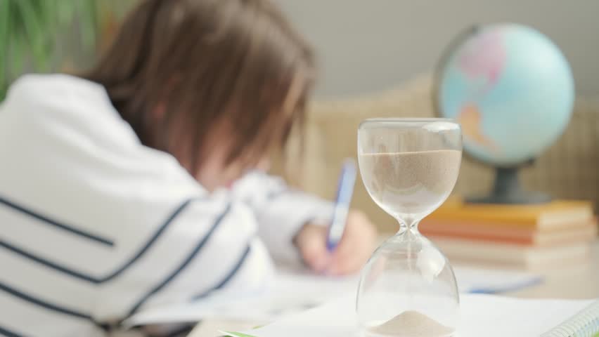 Teenager Student studying doing homework at desk with hourglass, education, knowledge and time management, writing, learning process, exam prep, child training, concentration and discipline sand timer - Powered by Shutterstock - Get 15% off with code: PIKWIZARD15