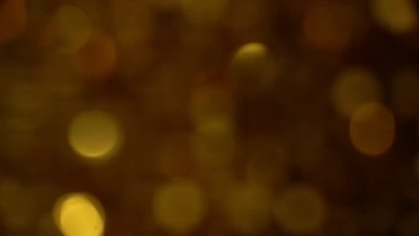 Golden bokeh background transitions through soft focus, showcasing shimmering lights and textures, creating a warm ambiance