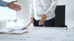 Business partnership success concept with handshake in modern office, financial charts, graphs and laptop on desk representing teamwork, agreement and corporate growth - Powered by Shutterstock - Get 15% off with code: PIKWIZARD15