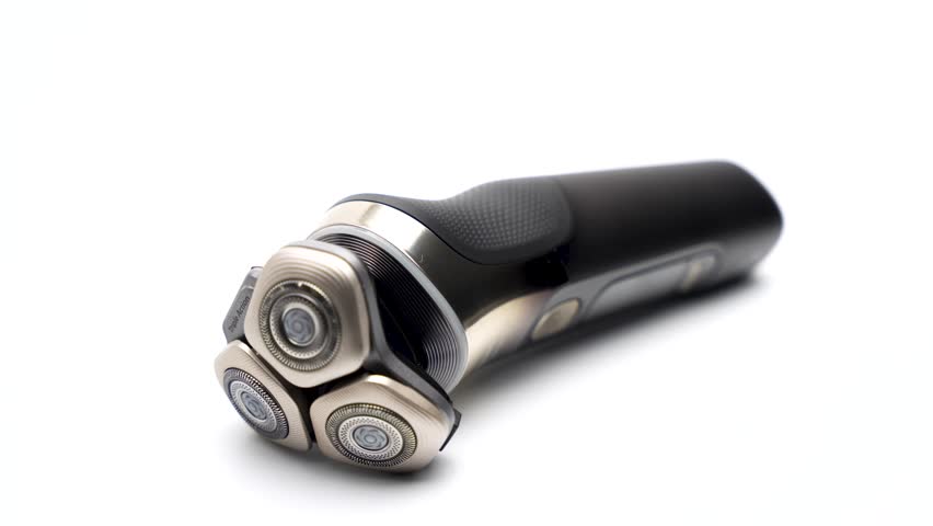 A modern electric rotary shaver slowly rotates on a bright white background. The full body and triple shaving heads are clearly visible.