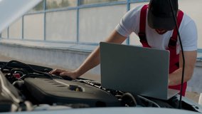 Technician using diagnostic computer to troubleshoot engine issues, focused on vehicle maintenance, with tools and equipment visible in a well-lit garage environment - Powered by Shutterstock - Get 15% off with code: PIKWIZARD15