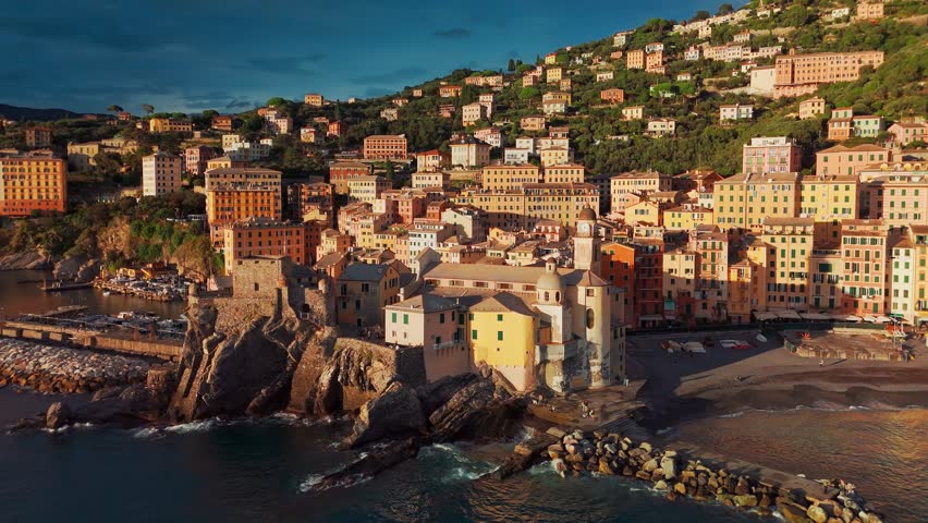 Aerial view of the picturesque historic town of Camogliat sunset in Liguria, Italy. Historic Castello della Dragonara and Basilica di Santa Maria Assunta with colorful buildings above Ligurian Sea