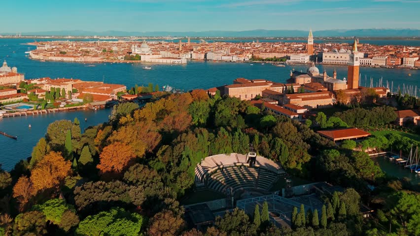 Aerial view of San Giorgio Maggiore island and Grand Canal in Venice, Italy, at sunrise. Stunning landscape of the Venetian lagoon with historic architecture and calm morning atmosphere.