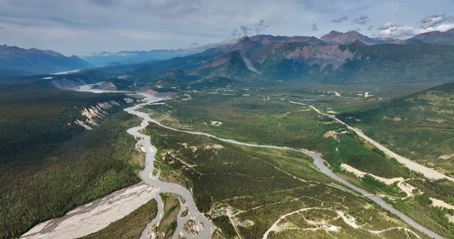 Scenic view on the wilderness of Alaska, USA. Drone footage over the vast valley, river and stunning mountains.