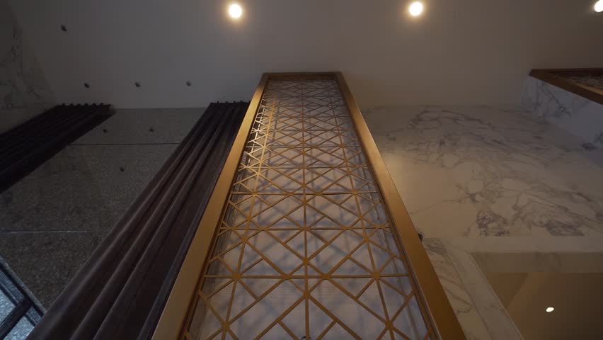 An elegant long-sleeved white wedding dress hangs on a decorative screen in a luxurious room. The scene evokes anticipation and romance, perfect for bridal content or luxury event promotions.