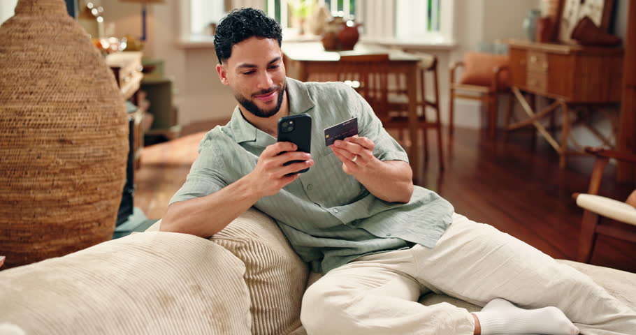 Credit card, smile or man on sofa with phone, online payment or sales promo in eft transaction. Happy, easy shopping or male person in home with tech, remote service and discount on cashless purchase