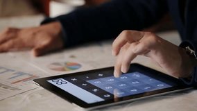 Busy financial adviser working with interactive graphics and charts on a tablet, ideal for business, finance, and digital analysis visuals. - Powered by Shutterstock - Get 15% off with code: PIKWIZARD15