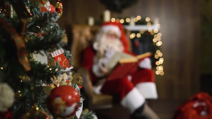 "Santa Claus sitting in an armchair on Christmas Eve, holding a red silk album, near a decorated Christmas tree with lights and toys."