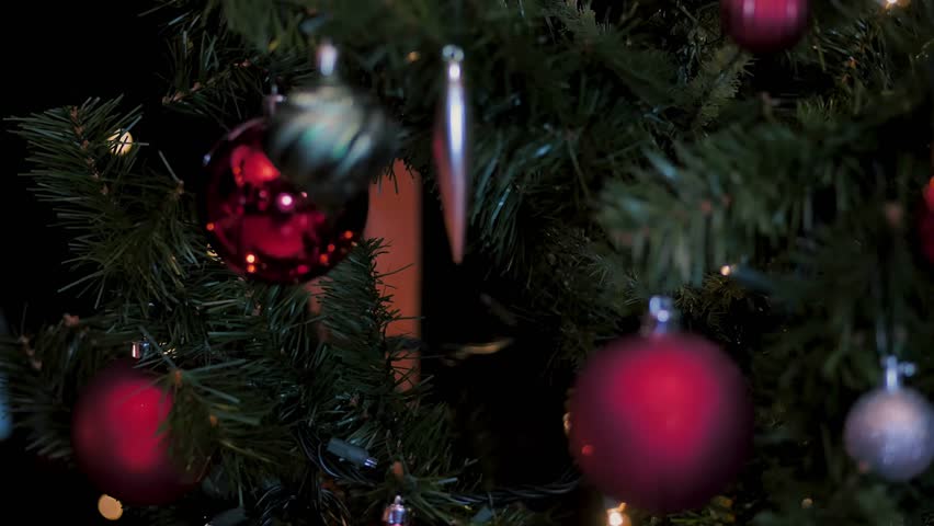 Close-up 4K footage of a beautifully decorated Christmas tree with glowing ornaments, sparkling lights and Soft camera movement creates a cozy holiday atmosphere.