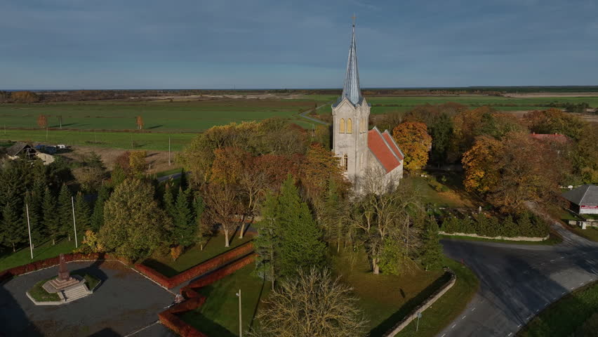 Aerial footage of one of the oldest churches in Estonia - Church of the Blessed Virgin Mary in Joelahtme (Estonian - Püha Neitsi Maarja kirik, Jõelähtme) on a sunny autumn day. 