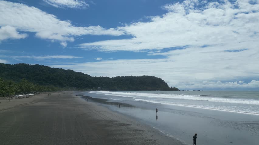 Aerial view of the beach with vegetation in the background on a warm morning at Jacó Beach located in the province of Puntarenas in Costa Rica