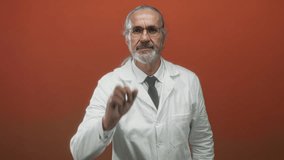 Man scientist with long grey hair and glasses points finger toward camera wearing lab coat in studio with orange backdrop; focus determination. - Powered by Shutterstock - Get 15% off with code: PIKWIZARD15
