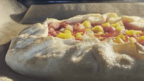 A close-up shot of a rustic, homemade fruit galette (open pie) baking inside a hot oven. The golden crust is setting, and the bright fruit filling (yellow and red pieces) is bubbling. - Powered by Shutterstock - Get 15% off with code: PIKWIZARD15