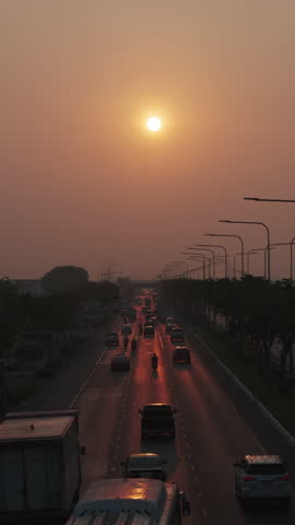 Cars traffic on a busy multi-lane road and sunset sun. Vertical video 4k