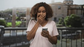 Woman holding smartphone, smiling and gesturing with open hand at building ruins balcony in rome; joy travel discovery. - Powered by Shutterstock - Get 15% off with code: PIKWIZARD15